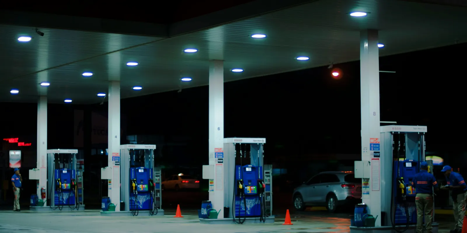 Una gasolinera de noche, con los surtidores iluminados bajo la marquesina